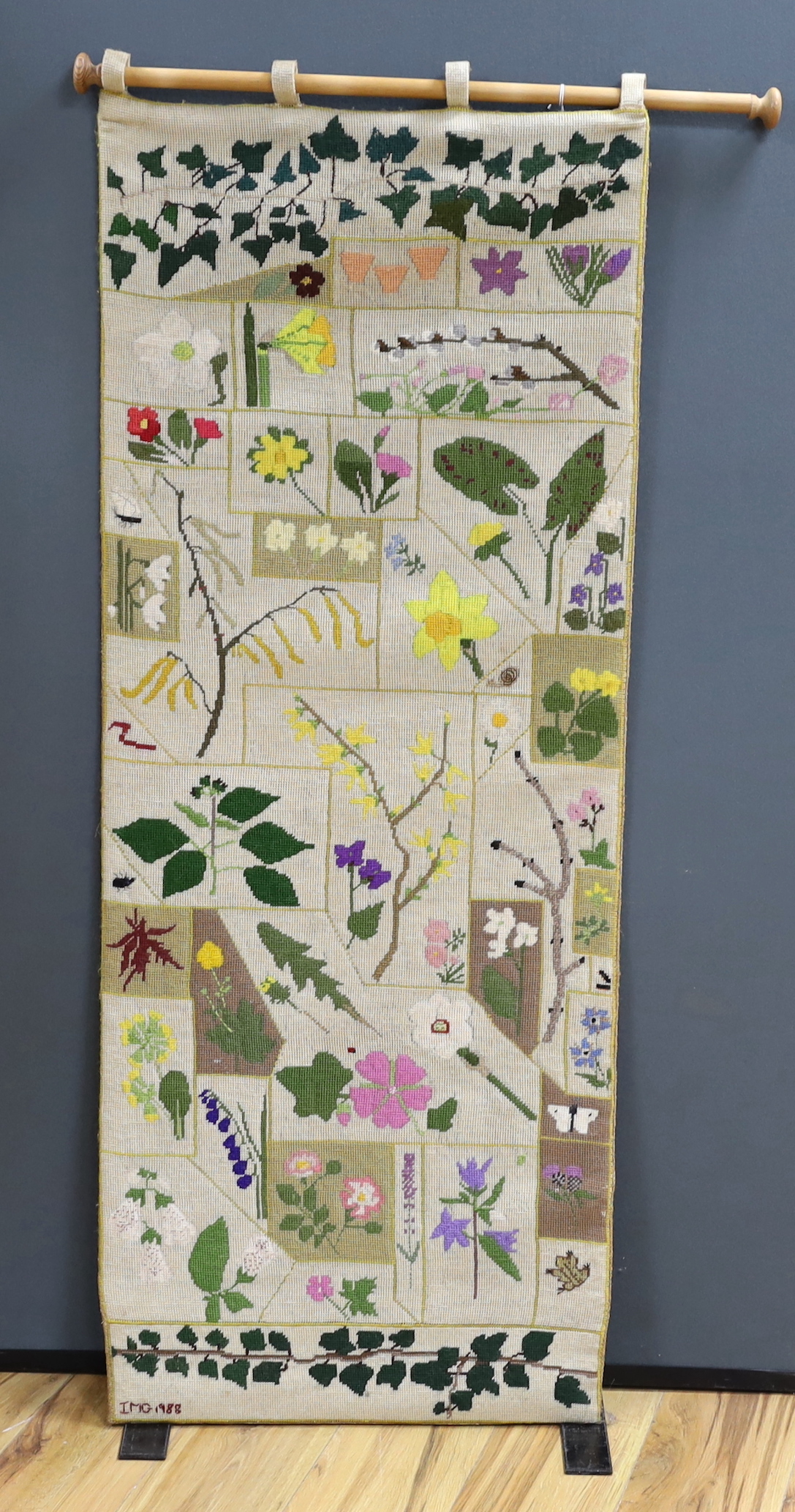 A cross-stitch wall hanging of wildflowers, 140cm high